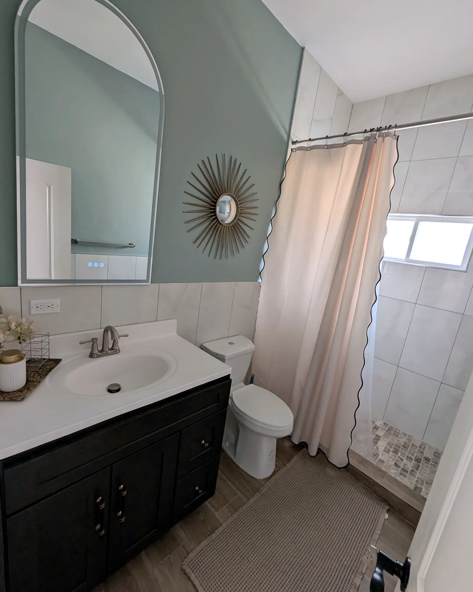 Bathroom with an arched mirror and sunburst mirror
