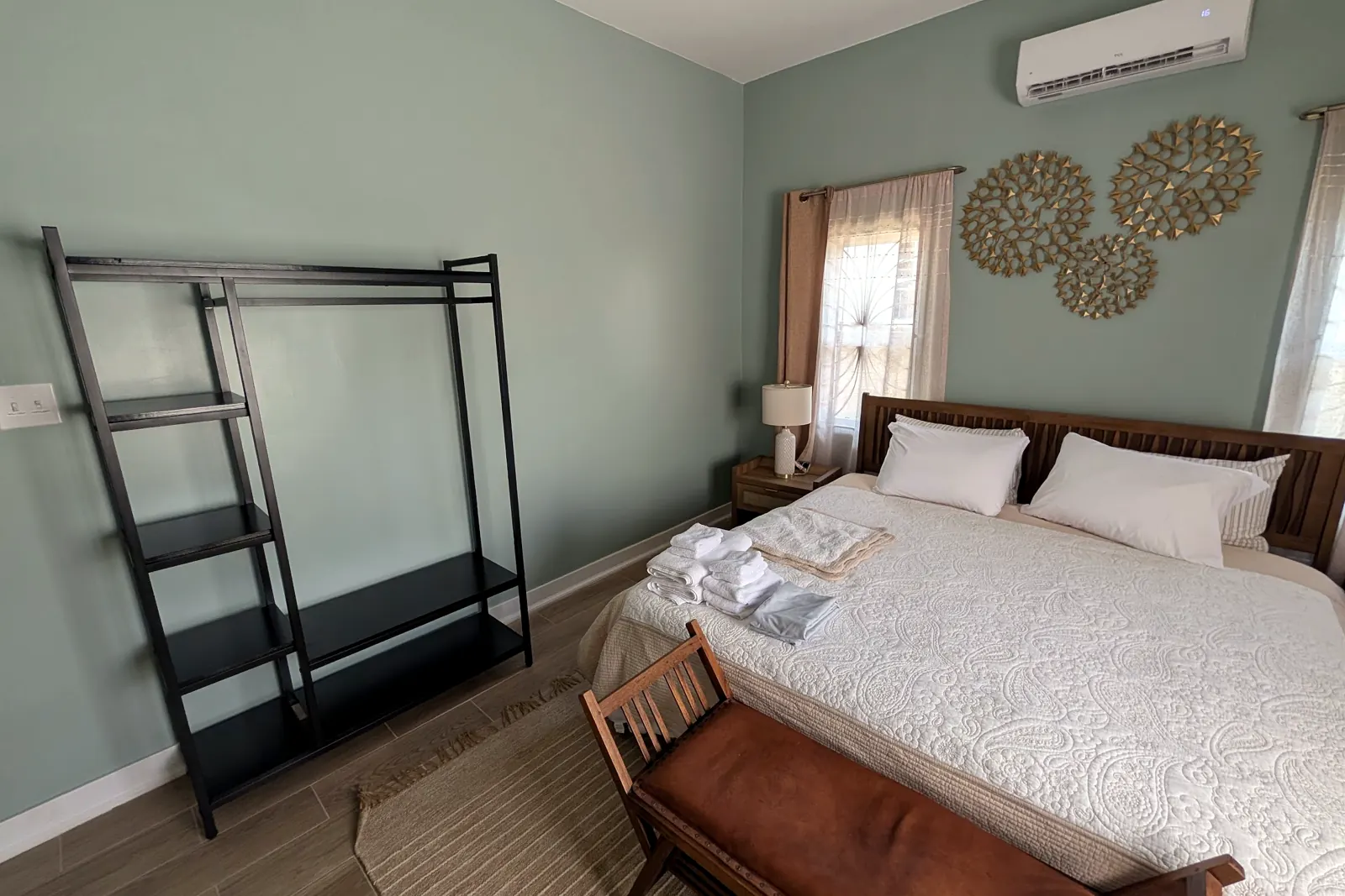 Main bedroom with woven wall discs and a king bed