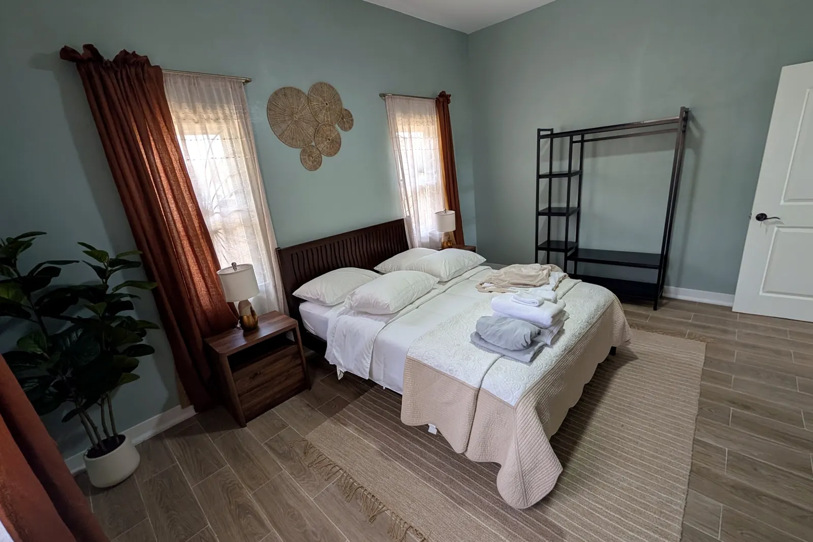 Second bedroom with rust curtains and a plant