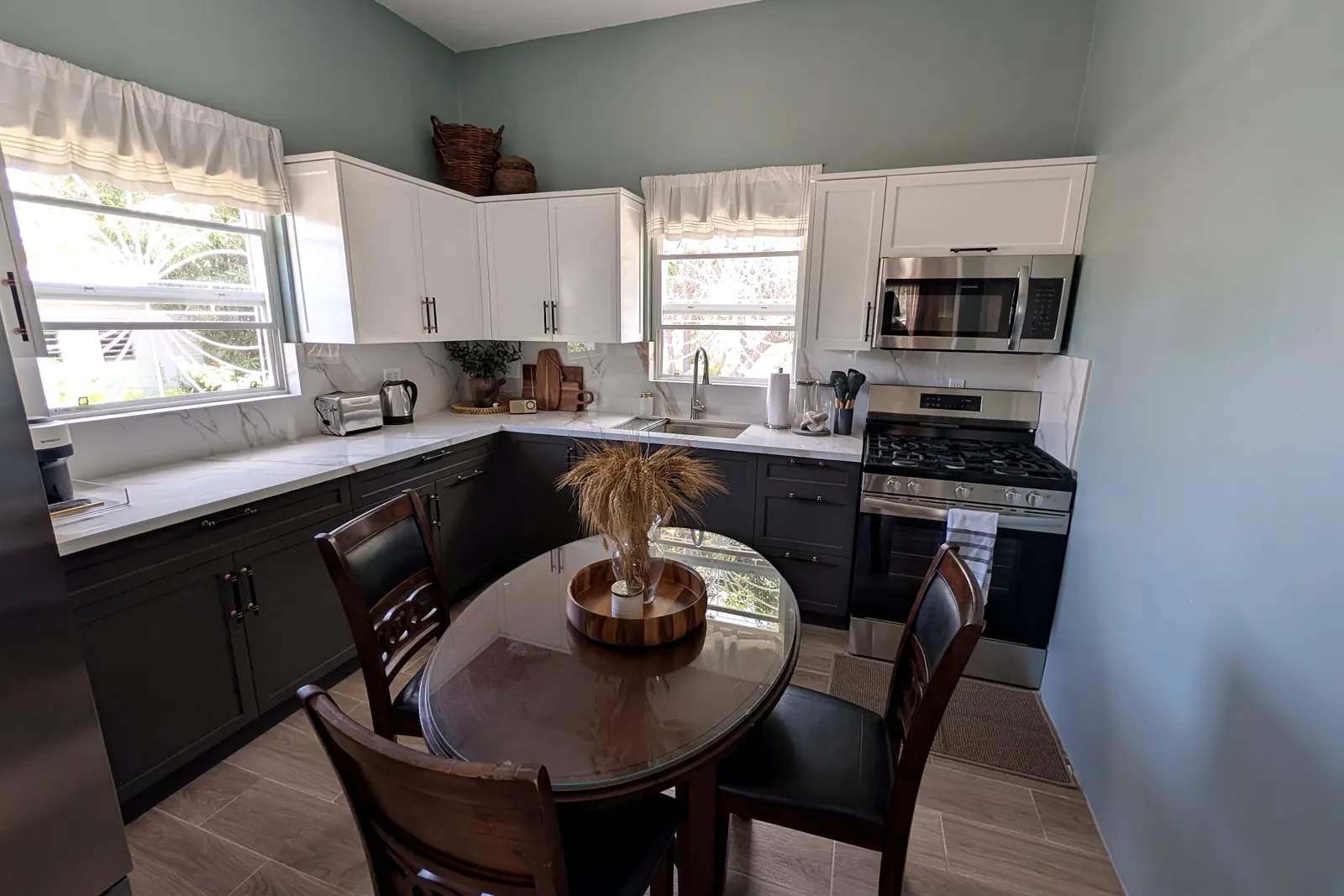 Kitchen with white upper cabinets and a round dining table