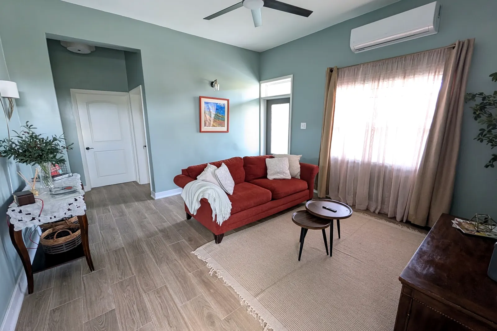 Living room with a rust-red sofa and ceiling fan